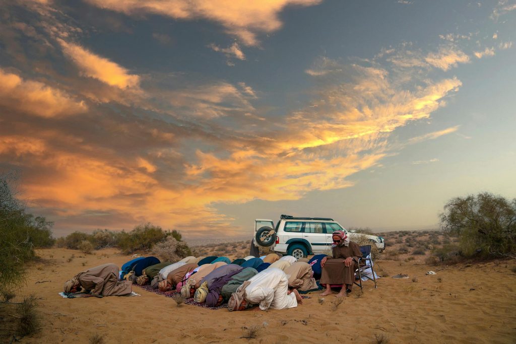 Men praying in the desert
